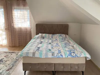 a bedroom with a bed with a blue and white comforter at Vila BD in Milešići
