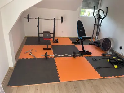 an attic gym with exercise equipment on an orange floor at Vila BD in Milešići