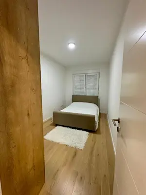 a small bedroom with a bed and a door at Apartment CHILL in Banja Luka