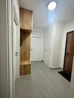 an empty hallway with white walls and a wooden staircase at Apartment CHILL in Banja Luka