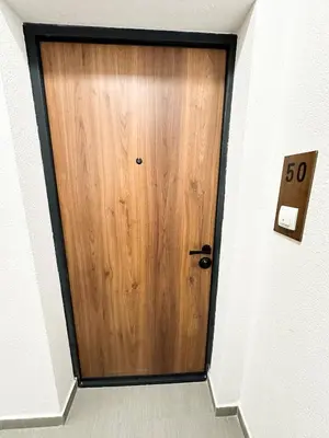 a wooden door in a hallway with a speed limit sign at Apartment CHILL in Banja Luka