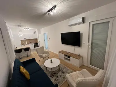 a living room with a blue couch and a tv at Apartment CHILL in Banja Luka