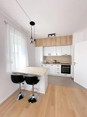 a kitchen with a table and two bar stools at Apartment CHILL in Banja Luka