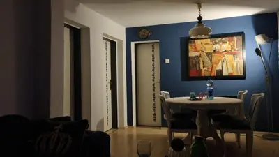 a dining room with a table and a blue wall at Bosnien Old House in Travnik