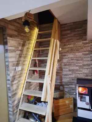 a staircase in a room with a brick wall at Vikendica Rajvosa Vlašić in Šišava