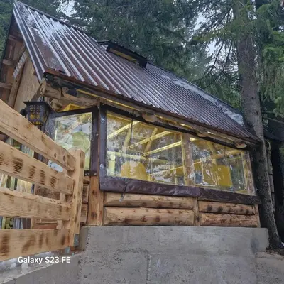 a log cabin with a glass window on it at Vikendica Rajvosa Vlašić in Šišava