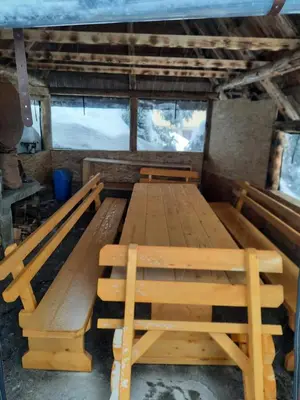 a large wooden table and benches in a room at Vikendica Rajvosa Vlašić in Šišava