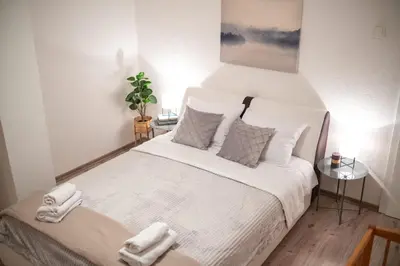 a bedroom with a large white bed with two towels at Kuća za odmor Mali raj-Kupres in Kupres