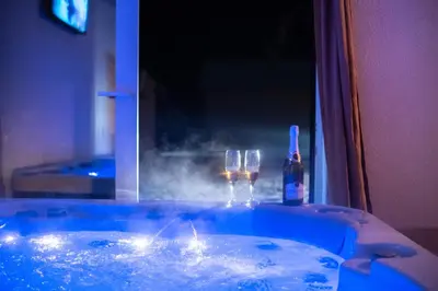 a hot tub with two wine glasses and a bottle at Kuća za odmor Mali raj-Kupres in Kupres