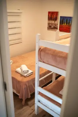 a room with two bunk beds and a table at Kuća za odmor Mali raj-Kupres in Kupres