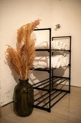 a black vase with dried grass in it next to a shelf at Kuća za odmor Mali raj-Kupres in Kupres
