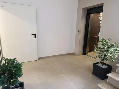 a hallway with two potted plants and a door at Apartman Bjanka in Banja Luka