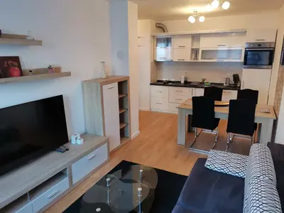 a kitchen and living room with a table and chairs at Apartment Banja Luka in Banja Luka