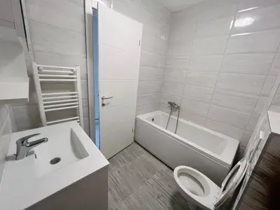 a white bathroom with a toilet and a sink at Apartman Maja Lux in Banja Luka