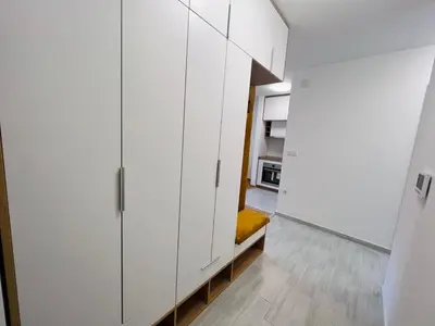 a room with white cabinets and a yellow bench in it at Apartman Maja Lux in Banja Luka