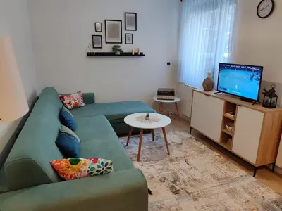a living room with a green couch and a television at Tuzlanska Panonica in Tuzla