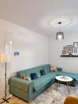 a living room with a green couch and a table at Tuzlanska Panonica in Tuzla