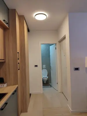 a bathroom with a toilet and a door to a room at Tuzlanska Panonica in Tuzla
