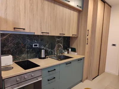 a kitchen with wooden cabinets and a sink at Tuzlanska Panonica in Tuzla
