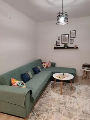 a living room with a green couch and a table at Panonika Tuzla in Tuzla