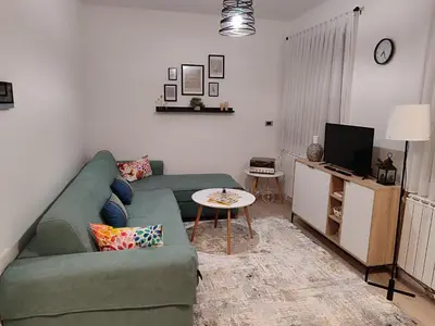 a living room with a green couch and a tv at Panonika Tuzla in Tuzla