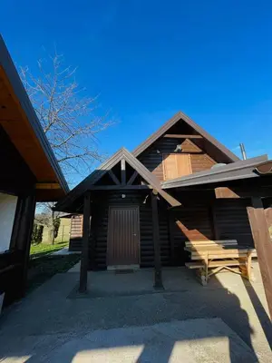 a log cabin with a gambrel roof and a porch at Vikendica Bajka in Banja Luka