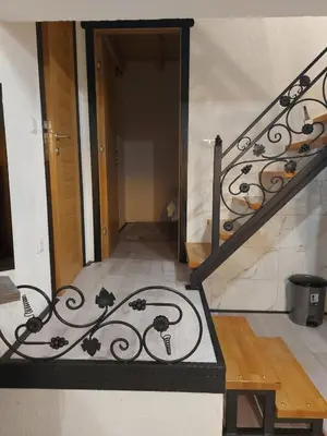 a stairway with a wrought iron railing and a door at Vikendica Striček in Kupres