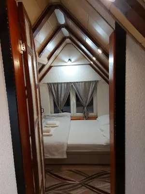 an open door to a bed in a room at Vikendica Striček in Kupres