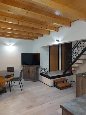 a living room with a television and a staircase at Vikendica Striček in Kupres