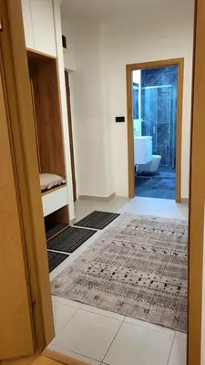 a bathroom with a door open to a bathroom with a tub at Apartment Urban Nest in Zenica