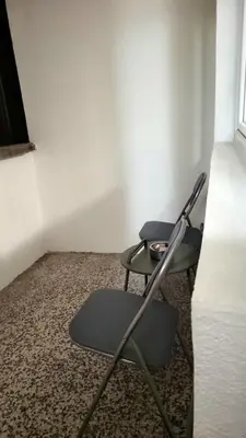 a chair sitting in a corner of a room at Apartment Urban Nest in Zenica