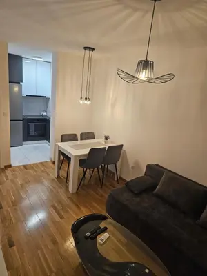 a living room with a couch and a table with chairs at Apartman Urukalo in Rebrovac
