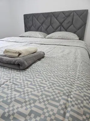 a bed with a blanket and pillows on it at Apartman Urukalo in Rebrovac