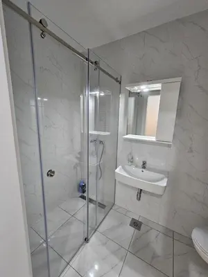 a bathroom with a shower and a sink at Apartman Urukalo in Rebrovac