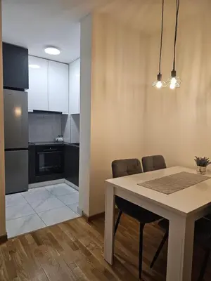 a kitchen and dining room with a table and chairs at Apartman Urukalo in Rebrovac