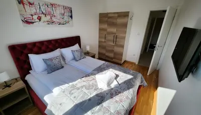 a bed with a red headboard in a bedroom at Ada Nostra in Banja Luka