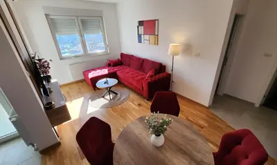 a living room with a red couch and a table at Ada Nostra in Banja Luka