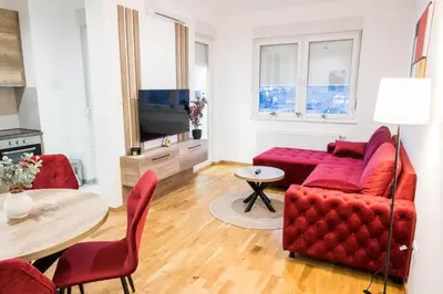a living room with a red couch and a table at Ada Nostra in Banja Luka