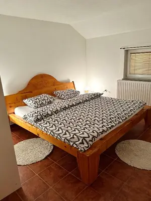 a bedroom with a large wooden bed with two pillows at Apartmani Ivan in Kupres