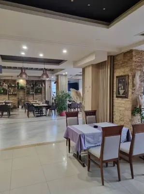 a dining room with a table and chairs and tables and a room with tables at Motel Bor in Vitez