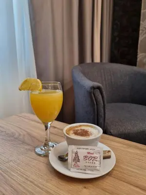 a glass of orange juice and a cup of coffee on a table at Motel Bor in Vitez
