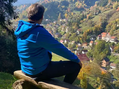 a man sitting on a bench looking at a valley at Villa Ruža Vareš in Vareš