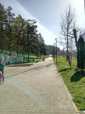 a walkway in a park with a person riding a bike at AS apartman Panonica in Tuzla