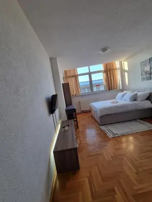 a bedroom with a bed and a table and a window at Mrakovica 1 in Prijedor
