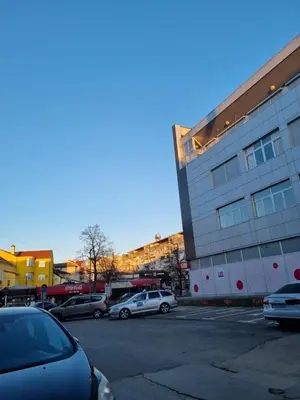 a parking lot with cars parked in front of a building at Mrakovica 1 in Prijedor