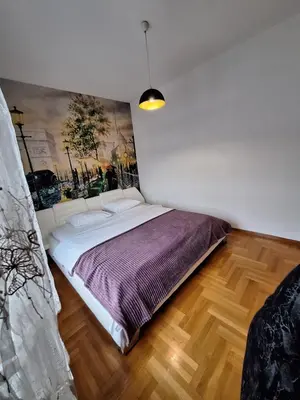 a bedroom with a bed with a painting on the wall at San apartment in Banja Luka