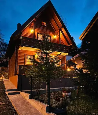 a house with a tree in front of it at Planinska kuća Mali Raj in Mrkonjić Grad