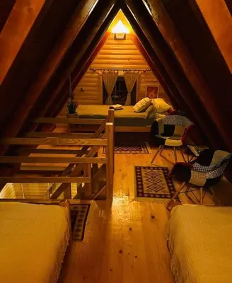 a attic room with three beds and a table at Planinska kuća Mali Raj in Mrkonjić Grad