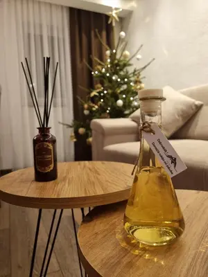 a bottle of oil on a table with a christmas tree at Villa Šola in Kupres