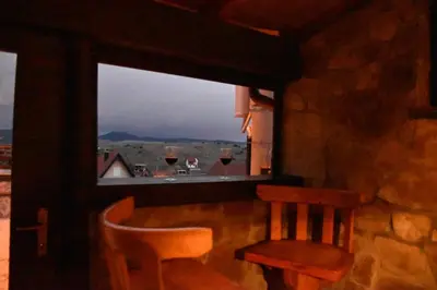 a window with a table and a chair and wine glasses at Villa Šola in Kupres